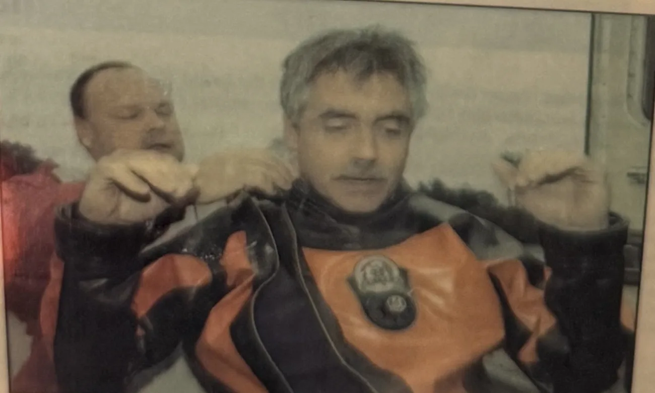 Greg Stone of Hart City SCUBA helping Vito Palumbo into his dry suit