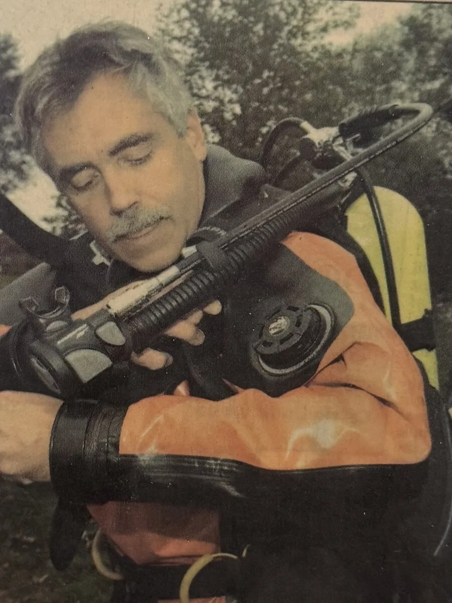 Vito Palumbo in a dry suit, checking his regulator before a dive team training exercise